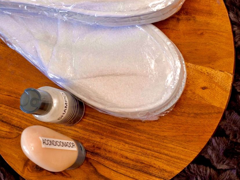 Perchero de madera con bata blanca tipo spa y toallas enrolladas