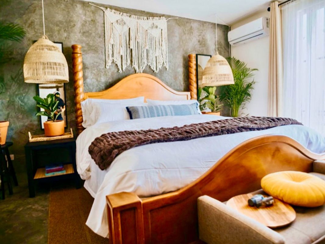 Recámara principal de Casa Blanca con cama California King y cabecera de madera tallada